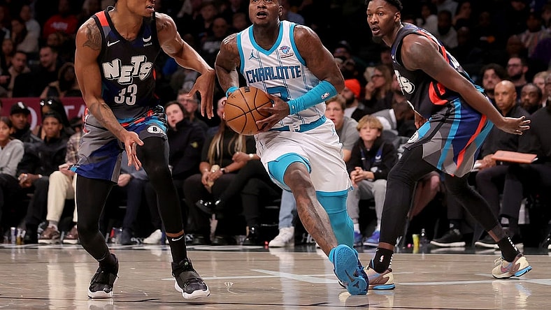 Nov 30, 2023; Brooklyn, New York, USA; Charlotte Hornets guard Terry Rozier (3) drives to the basket against Brooklyn Nets center Nic Claxton (33) and forward Dorian Finney-Smith (28) during the fourth quarter at Barclays Center. Mandatory Credit: Brad Penner-USA TODAY Sports