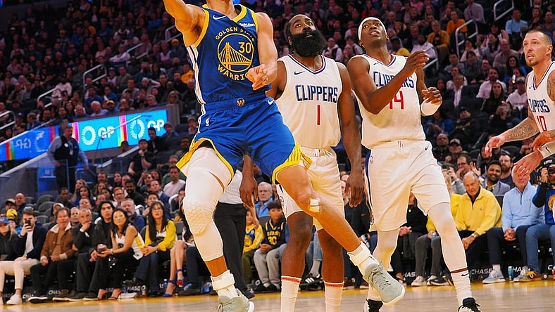 Nov 30, 2023; San Francisco, California, USA; Golden State Warriors guard Stephen Curry (30) scores against Los Angeles Clippers guard James Harden (1), guard Terance Mann (14) during the fourth quarter at Chase Center. Mandatory Credit: Kelley L Cox-USA TODAY Sports
