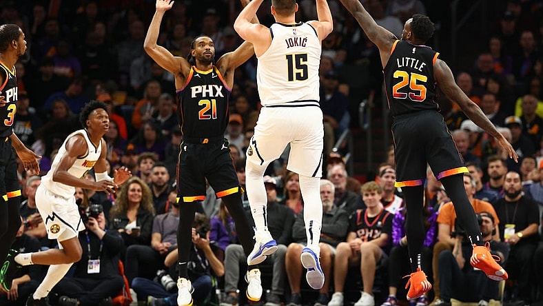 Dec 1, 2023; Phoenix, Arizona, USA; Denver Nuggets center Nikola Jokic (15) passes the ball against Phoenix Suns forward Keita Bates-Diop (21) and forward Nassir Little (25) in the first half at Footprint Center. Mandatory Credit: Mark J. Rebilas-USA TODAY Sports