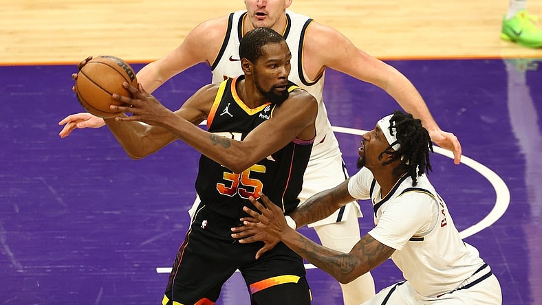 Dec 1, 2023; Phoenix, Arizona, USA; Phoenix Suns forward Kevin Durant (35) controls the ball under pressure from Denver Nuggets guard Kentavious Caldwell-Pope (5) and center Nikola Jokic (15) in the second half at Footprint Center. Mandatory Credit: Mark J. Rebilas-USA TODAY Sports