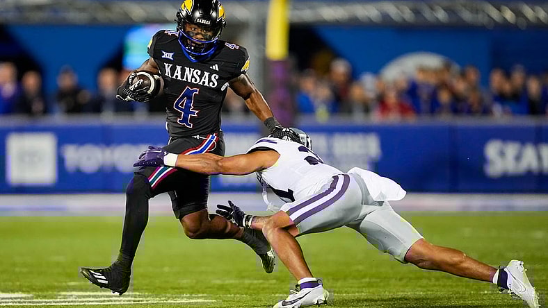 Nov 18, 2023; Lawrence, Kansas, USA; Kansas Jayhawks running back Devin Neal (4) runs the ball against Kansas State Wildcats safety Marques Sigle (21) during the first half at David Booth Kansas Memorial Stadium. Mandatory Credit: Jay Biggerstaff-USA TODAY Sports