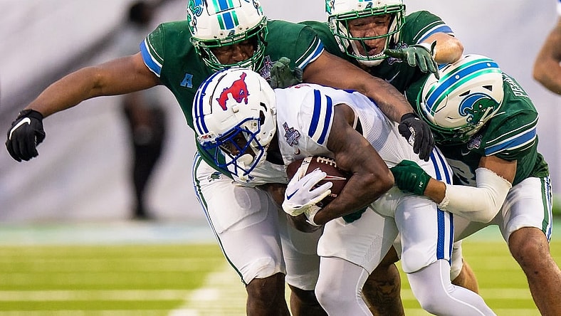 Dec 2, 2023; New Orleans, LA, USA; Southern Methodist Mustangs running back LJ Johnson Jr. (11) is tackled by Tulane Green Wave safety Kam Pedescleaux (8) during the first half at Yulman Stadium. Mandatory Credit: Stephen Lew-USA TODAY Sports