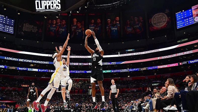Dec 2, 2023; Los Angeles, California, USA; Los Angeles Clippers forward Paul George (13) shoots against Golden State Warriors guard Moses Moody (4) during the second half at Crypto.com Arena. Mandatory Credit: Gary A. Vasquez-USA TODAY Sports