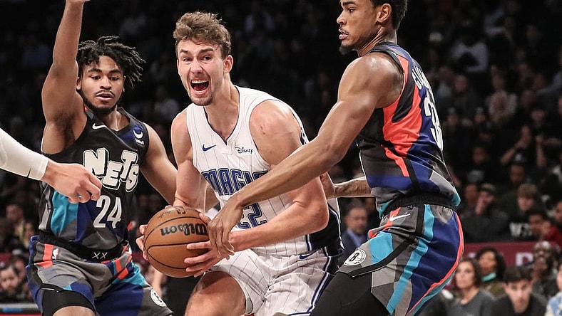 Dec 2, 2023; Brooklyn, New York, USA;  Orlando Magic forward Franz Wagner (22) looks to drive in between Brooklyn Nets guard Cam Thomas (24) and center Nic Claxton (33) in the second quarter at Barclays Center. Mandatory Credit: Wendell Cruz-USA TODAY Sports