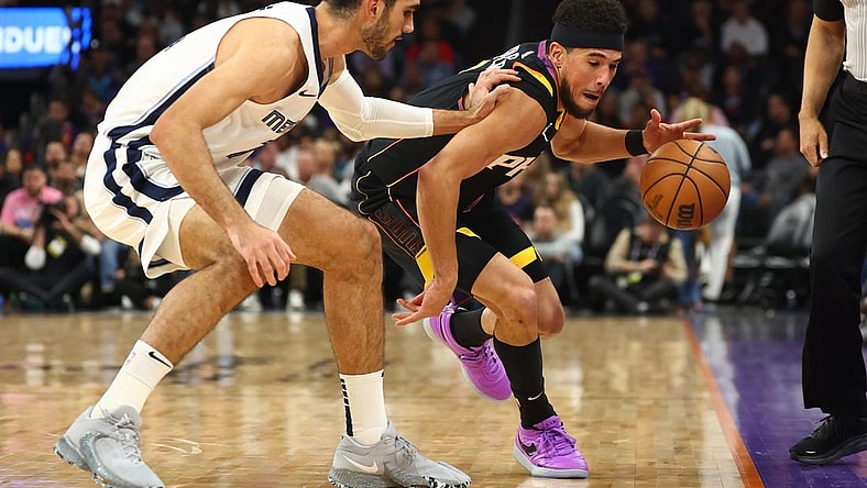 Dec 2, 2023; Phoenix, Arizona, USA; Phoenix Suns guard Devin Booker (right) steals the ball from Memphis Grizzlies forward Santi Aldama in the first half at Footprint Center. Mandatory Credit: Mark J. Rebilas-USA TODAY Sports