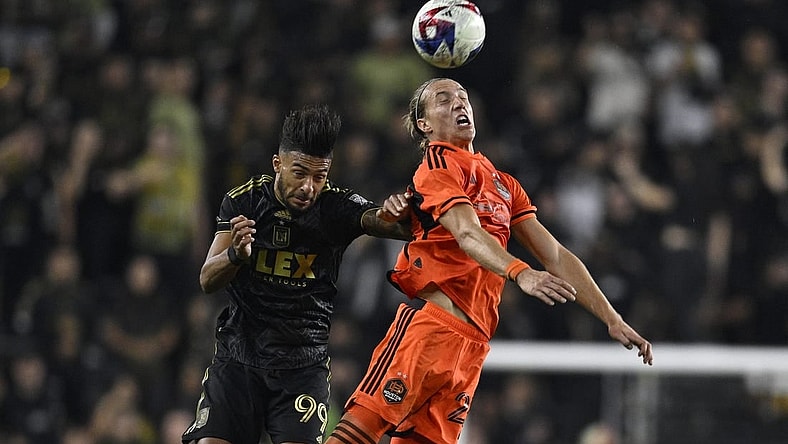 Dec 2, 2023; Los Angeles, California, USA; Houston Dynamo midfielder Griffin Dorsey (25) heads the ball past Los Angeles FC forward Denis Bouanga (99) for the MLS Cup Western Conference Final at BMO Stadium. Mandatory Credit: Kelvin Kuo-USA TODAY Sports