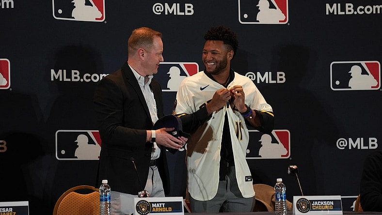 Dec 4, 2023; Nashville, TN, USA; Milwaukee Brewers general manager Matt Arnold presents Jackson Chourio with a team uniform and hat during the MLB 2023 Winter Meetings. Mandatory Credit: Kyle Schwab-USA TODAY Sports