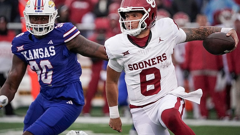 Oct 28, 2023; Lawrence, Kansas, USA; Oklahoma Sooners quarterback Dillon Gabriel (8) runs the ball as Kansas Jayhawks linebacker Rich Miller (30) defends during the game at David Booth Kansas Memorial Stadium. Mandatory Credit: Denny Medley-USA TODAY Sports