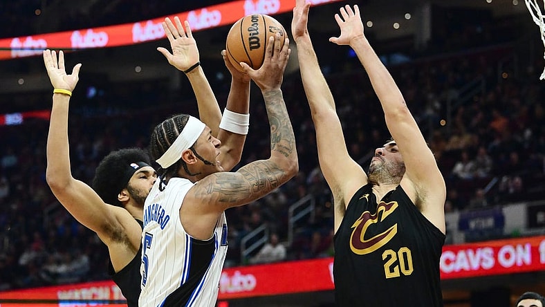 Dec 6, 2023; Cleveland, Ohio, USA; Orlando Magic forward Paolo Banchero (5) drives to the basket between Cleveland Cavaliers center Jarrett Allen (31) and forward Georges Niang (20) during the first half at Rocket Mortgage FieldHouse. Mandatory Credit: Ken Blaze-USA TODAY Sports