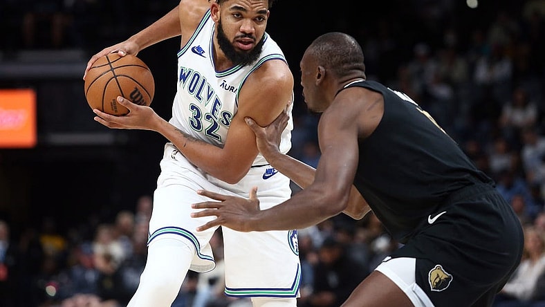 Dec 8, 2023; Memphis, Tennessee, USA; Minnesota Timberwolves center-forward Karl-Anthony Towns (32) handles the ball as Memphis Grizzlies center Bismack Biyombo (18) defends during the first half at FedExForum. Mandatory Credit: Petre Thomas-USA TODAY Sports