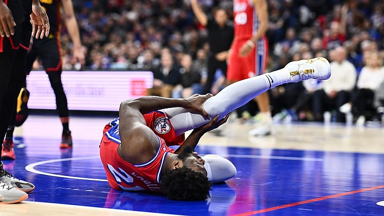 Dec 8, 2023; Philadelphia, Pennsylvania, USA; Philadelphia 76ers center Joel Embiid (21) grabs his knee after falling against the Atlanta Hawks in the fourth quarter at Wells Fargo Center. Mandatory Credit: Kyle Ross-USA TODAY Sports