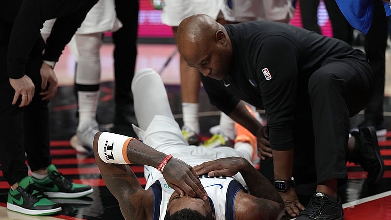 Dec 8, 2023; Portland, Oregon, USA; Dallas Mavericks point guard Kyrie Irving (11) is checked by a staff member during the first half against the Portland Trail Blazers at Moda Center. Mandatory Credit: Soobum Im-USA TODAY Sports