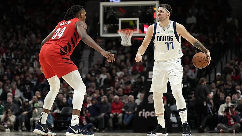 Dec 8, 2023; Portland, Oregon, USA; Dallas Mavericks point guard Luka Doncic (77) brings the ball up court against Portland Trail Blazers forward Jabari Walker (34) during the second half at Moda Center. Mandatory Credit: Soobum Im-USA TODAY Sports