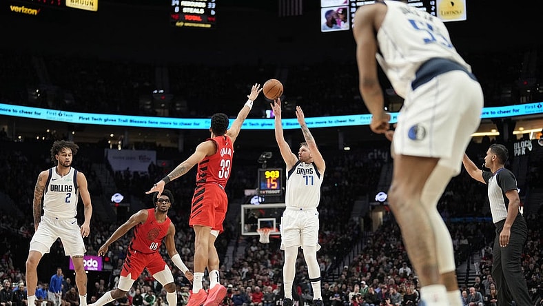 Dec 8, 2023; Portland, Oregon, USA; Dallas Mavericks point guard Luka Doncic (77) shoots the ball over Portland Trail Blazers forward Toumani Camara (33) during the second half at Moda Center. Mandatory Credit: Soobum Im-USA TODAY Sports