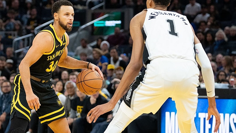 November 24, 2023; San Francisco, California, USA; Golden State Warriors guard Stephen Curry (30) dribbles the basketball against San Antonio Spurs center Victor Wembanyama (1) during the fourth quarter at Chase Center. Mandatory Credit: Kyle Terada-USA TODAY Sports