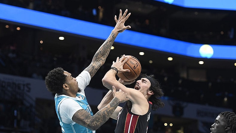 Dec 11, 2023; Charlotte, North Carolina, USA; Miami Heat forward Jaime Jaquez Jr. (11) shoots as he is defended by Charlotte Hornets forward P.J. Washington (25) during the first half at the Spectrum Center. Mandatory Credit: Sam Sharpe-USA TODAY Sports