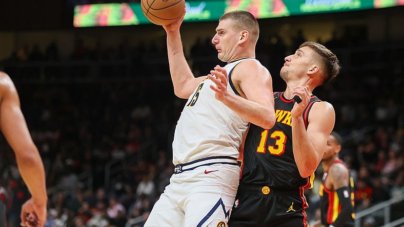 Dec 11, 2023; Atlanta, Georgia, USA; Denver Nuggets center Nikola Jokic (15) is defended by Atlanta Hawks guard Bogdan Bogdanovic (13) in the second quarter at State Farm Arena. Mandatory Credit: Brett Davis-USA TODAY Sports
