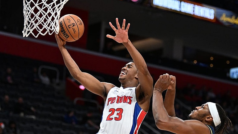 Dec 11, 2023; Detroit, Michigan, USA;  Detroit Pistons guard Jaden Ivey (23) drives to the basket for a layup over Indiana Pacers forward Isaiah Jackson (22) in the fourth quarter at Little Caesars Arena. Mandatory Credit: Lon Horwedel-USA TODAY Sports