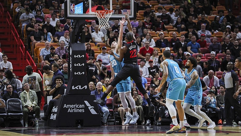 Dec 13, 2023; Miami, Florida, USA; Miami Heat forward Jimmy Butler (22) shoots the basketball over Charlotte Hornets forward Gordon Hayward (20) during the first quarter at Kaseya Center. Mandatory Credit: Sam Navarro-USA TODAY Sports