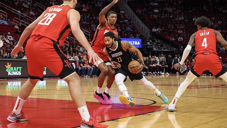 Dec 13, 2023; Houston, Texas, USA; Memphis Grizzlies guard Derrick Rose (23) splits the defense of Houston Rockets forward Jabari Smith Jr. (10) and Hguard Jalen Green (4) and against  center Alperen Sengun (28)  in the first quarter at Toyota Center. Mandatory Credit: Thomas Shea-USA TODAY Sports