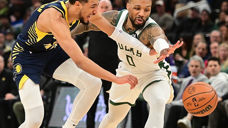 Dec 13, 2023; Milwaukee, Wisconsin, USA; Indiana Pacers guard Tyrese Haliburton (0) and Milwaukee Bucks guard Damian Lillard (0) reach for a loose ball in the first quarter at Fiserv Forum. Mandatory Credit: Benny Sieu-USA TODAY Sports