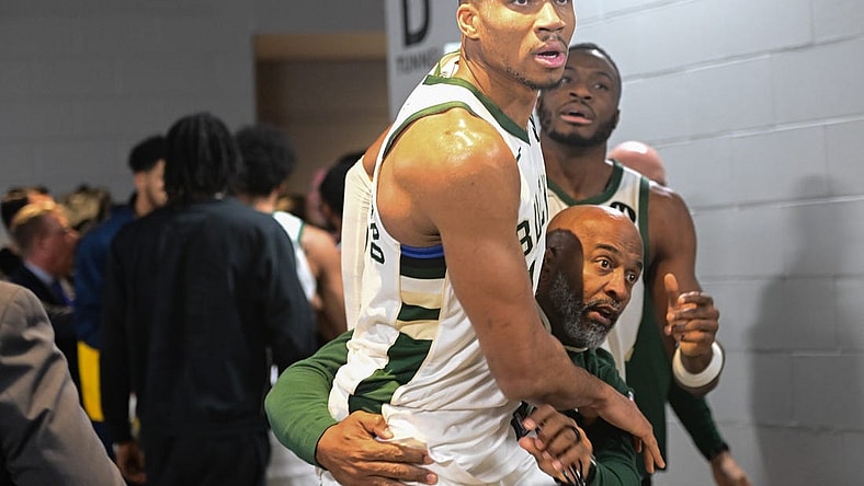 Dec 13, 2023; Milwaukee, Wisconsin, USA;  Milwaukee Bucks forward Giannis Antetokounmpo (34) is restrained by a coach outside the Indiana Pacers locker room after the game at Fiserv Forum. Mandatory Credit: Benny Sieu-USA TODAY Sports