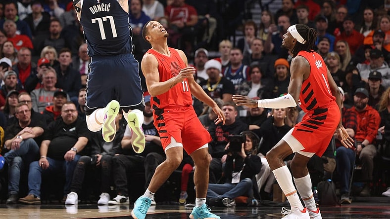 Dec 16, 2023; Portland, Oregon, USA; Dallas Mavericks guard Luka Doncic (77) shoots the ball after drawing a foul against Portland Trail Blazers guard Malcolm Brogdon (11)  in the first half at Moda Center. Mandatory Credit: Jaime Valdez-USA TODAY Sports