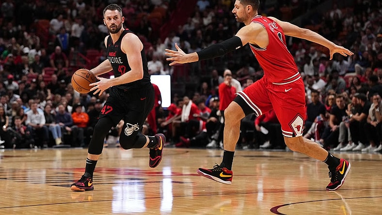 Dec 16, 2023; Miami, Florida, USA; Miami Heat forward Kevin Love (42) dribbles the ball around Miami Heat guard Dru Smith (9) during the second half at Kaseya Center. Mandatory Credit: Jasen Vinlove-USA TODAY Sports