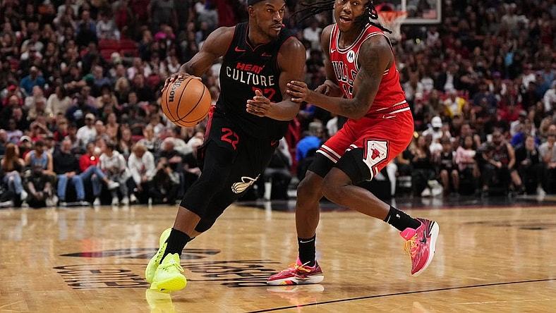 Dec 16, 2023; Miami, Florida, USA; Miami Heat forward Jimmy Butler (22) drives the ball around Chicago Bulls guard Ayo Dosunmu (12) during the second half at Kaseya Center. Mandatory Credit: Jasen Vinlove-USA TODAY Sports