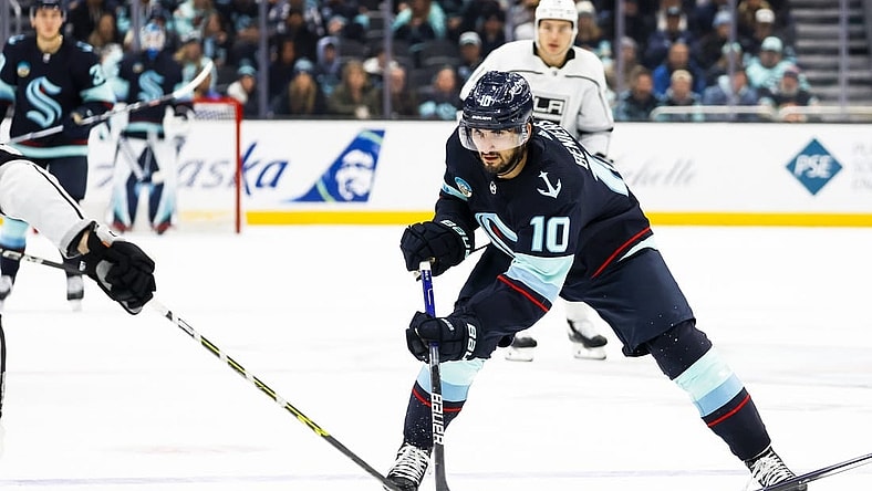 Dec 16, 2023; Seattle, Washington, USA; Seattle Kraken center Matty Beniers (10) flips the puck forward against the Los Angeles Kings during the second period at Climate Pledge Arena. Mandatory Credit: Joe Nicholson-USA TODAY Sports