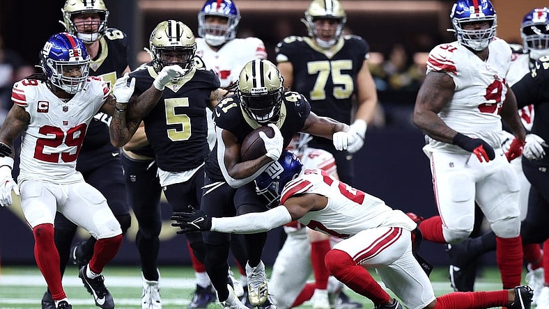 Dec 17, 2023; New Orleans, Louisiana, USA; New Orleans Saints running back Alvin Kamara (41) is tackled by New York Giants safety Jason Pinnock (27) during the second half at Caesars Superdome. Mandatory Credit: Stephen Lew-USA TODAY Sports