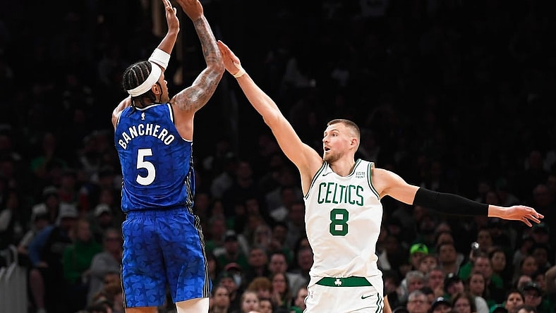 Dec 17, 2023; Boston, Massachusetts, USA;  Orlando Magic forward Paolo Banchero (5) shoots the ball over Boston Celtics center Kristaps Porzingis (8) during the second half at TD Garden. Mandatory Credit: Bob DeChiara-USA TODAY Sports