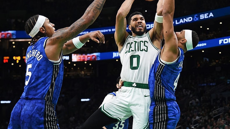 Dec 17, 2023; Boston, Massachusetts, USA;  Boston Celtics forward Jayson Tatum (0) drives to the basket between Orlando Magic forward Paolo Banchero (5) and guard Jalen Suggs (4) during the second half at TD Garden. Mandatory Credit: Bob DeChiara-USA TODAY Sports