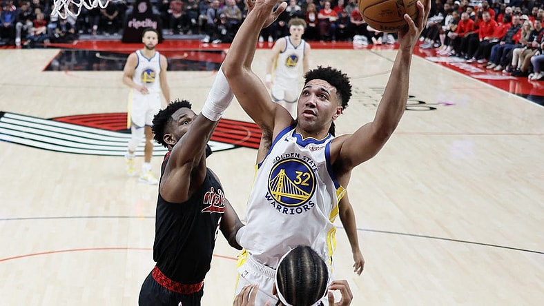 Dec 17, 2023; Portland, Oregon, USA; Golden State Warriors forward Trayce Jackson-Davis (32) shoots the ball over Portland Trail Blazers center Deandre Anton (2, left) during the second half at Moda Center. Mandatory Credit: Soobum Im-USA TODAY Sports