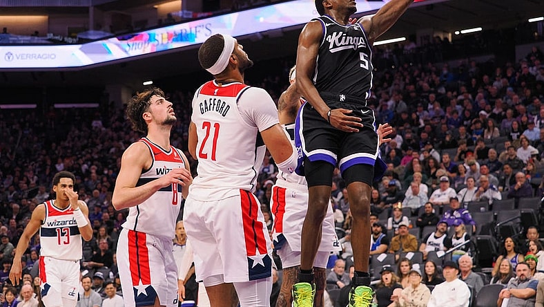 Dec 18, 2023; Sacramento, California, USA; Sacramento Kings guard De'Aaron Fox (5) scores a layup against Washington Wizards center Daniel Gafford (21) during the second quarter at Golden 1 Center. Mandatory Credit: Kelley L Cox-USA TODAY Sports