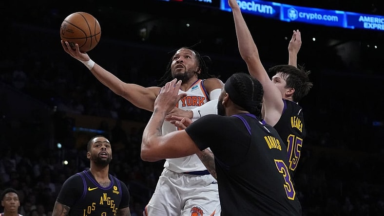 Dec 18, 2023; Los Angeles, California, USA; New York Knicks guard Immanuel Quickley (5) shoots the ball against Los Angeles Lakers guard D'Angelo Russell (1), forward Anthony Davis (3) and guard Austin Reaves (15) in the first half at Crypto.com Arena. Mandatory Credit: Kirby Lee-USA TODAY Sports
