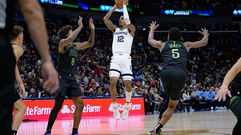 Dec 19, 2023; New Orleans, Louisiana, USA;  Memphis Grizzlies guard Ja Morant (12) shoots in between New Orleans Pelicans forwards Naji Marshall (8) and Herbert Jones (5) during the second quarter at the Smoothie King Center. Mandatory Credit: Matthew Hinton-USA TODAY Sports
