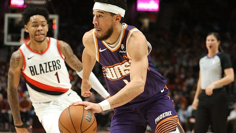 Dec 19, 2023; Portland, Oregon, USA; Phoenix Suns guard Devin Booker (1) drives the ball past Portland Trail Blazers guard Anfernee Simons (1) in the third quarter at Moda Center. Mandatory Credit: Jaime Valdez-USA TODAY Sports