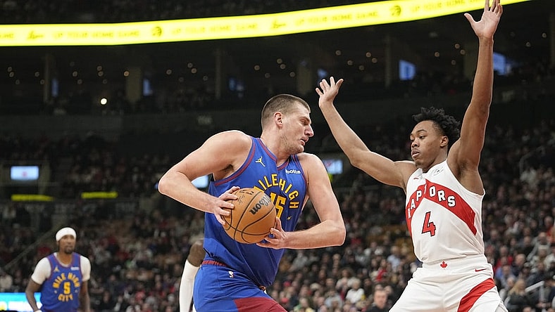 Dec 20, 2023; Toronto, Ontario, CAN; Denver Nuggets center Nikola Jokic (15) drives to the net against Toronto Raptors forward Scottie Barnes (4) during the first half at Scotiabank Arena. Mandatory Credit: John E. Sokolowski-USA TODAY Sports