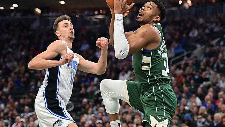 Dec 21, 2023; Milwaukee, Wisconsin, USA; Milwaukee Bucks forward Giannis Antetokounmpo (34) takes a shot against Orlando Magic forward Franz Wagner (22) in the first quarter at Fiserv Forum. Mandatory Credit: Benny Sieu-USA TODAY Sports