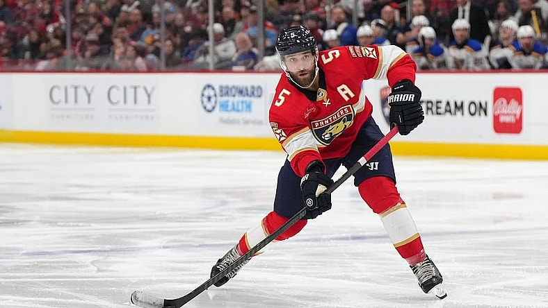 Dec 21, 2023; Sunrise, Florida, USA; Florida Panthers defenseman Aaron Ekblad (5) passes the puck against the St. Louis Blues during the second period at Amerant Bank Arena. Mandatory Credit: Jasen Vinlove-USA TODAY Sports