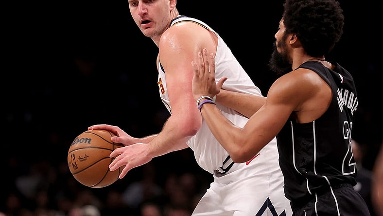 Dec 22, 2023; Brooklyn, New York, USA; Denver Nuggets center Nikola Jokic (15) controls the ball against Brooklyn Nets guard Spencer Dinwiddie (26) during the second quarter at Barclays Center. Mandatory Credit: Brad Penner-USA TODAY Sports