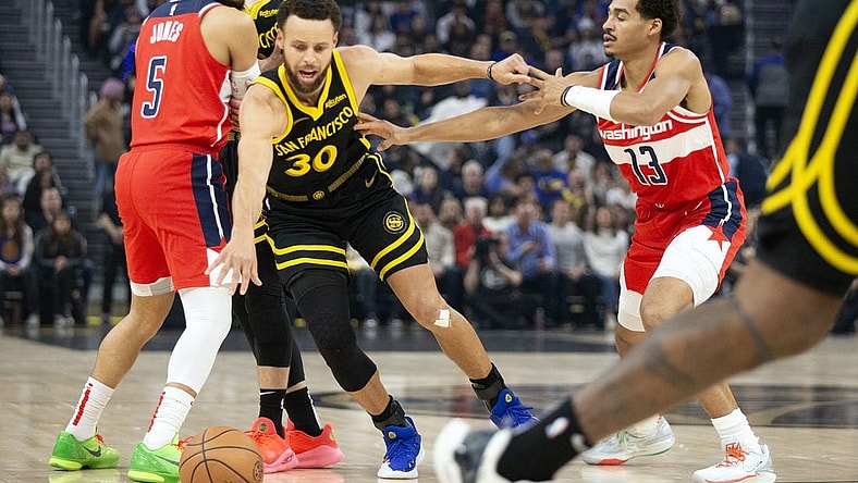 Dec 22, 2023; San Francisco, California, USA; Golden State Warriors guard Stephen Curry (30) dribbles away from pressure by Washington Wizards guard Jordan Poole (13) during the first quarter at Chase Center. Mandatory Credit: D. Ross Cameron-USA TODAY Sports