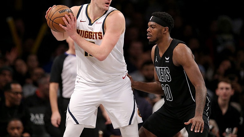Dec 22, 2023; Brooklyn, New York, USA; Denver Nuggets center Nikola Jokic (15) controls the ball against Brooklyn Nets center Day'Ron Sharpe (20) during the fourth quarter at Barclays Center. Mandatory Credit: Brad Penner-USA TODAY Sports