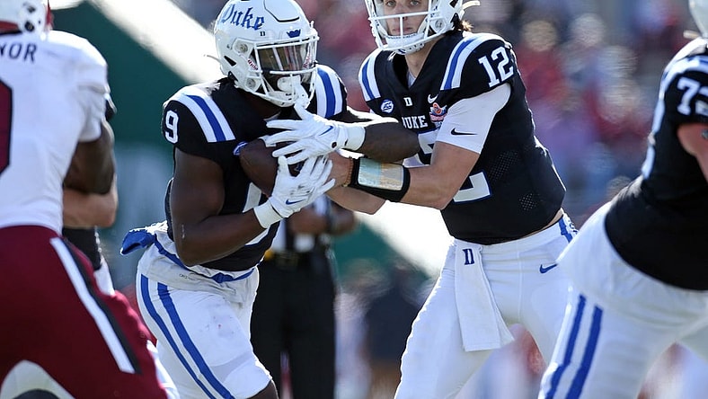 Dec 23, 2023; Birmingham, AL, USA; Duke Blue Devils quarterback Grayson Loftis (12) hands the ball off to Duke Blue Devils running back Jaquez Moore (9) during the first half against the Troy Trojans at Protective Stadium. Mandatory Credit: Petre Thomas-USA TODAY Sports