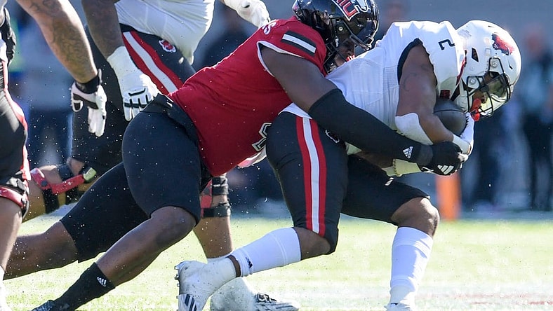 Arkansas State Red Wolves running back Ja'Quez Cross (2) is stopped by Northern Illinois Huskies defensive end Raishein Thomas (4) in first half action in the Camellia Bowl at Cramton Bowl in Montgomery, Ala., on Saturday December 23, 2023.