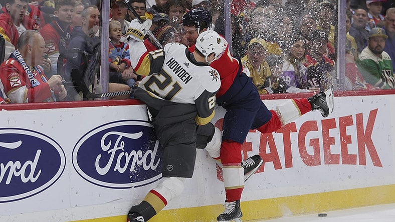 Dec 23, 2023; Sunrise, Florida, USA; Vegas Golden Knights center Brett Howden (21) and Florida Panthers defenseman Dmitry Kulikov (7) battle for the puck during the first period at Amerant Bank Arena. Mandatory Credit: Sam Navarro-USA TODAY Sports