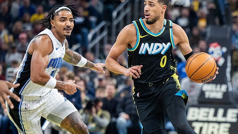 Dec 23, 2023; Indianapolis, Indiana, USA;  Indiana Pacers guard Tyrese Haliburton (0) dribbles the ball while Orlando Magic guard Gary Harris (14) defends in the first quarter at Gainbridge Fieldhouse. Mandatory Credit: Trevor Ruszkowski-USA TODAY Sports