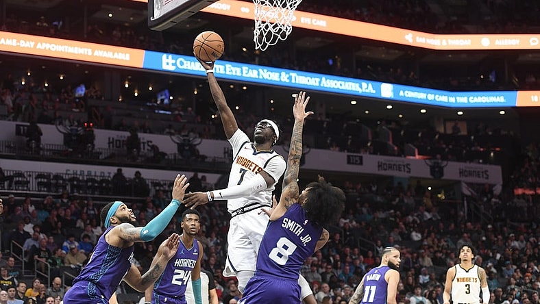 Dec 23, 2023; Charlotte, North Carolina, USA;  Denver Nuggets guard Reggie Jackson (7) drives against Charlotte Hornets forward Miles Bridges (0) and guard Nick Smith Jr. (8) during the first half at the Spectrum Center. Mandatory Credit: Sam Sharpe-USA TODAY Sports