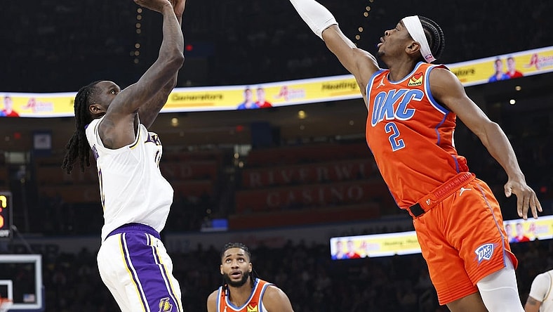 Dec 23, 2023; Oklahoma City, Oklahoma, USA; Los Angeles Lakers forward Taurean Prince (12) shoots as Oklahoma City Thunder guard Shai Gilgeous-Alexander (2) defends during the second quarter at Paycom Center. Mandatory Credit: Alonzo Adams-USA TODAY Sports